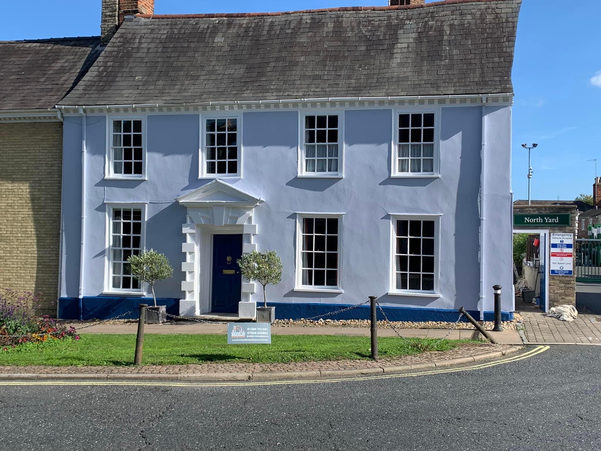 The Georgian house after, painted pale blue with a white doorcase