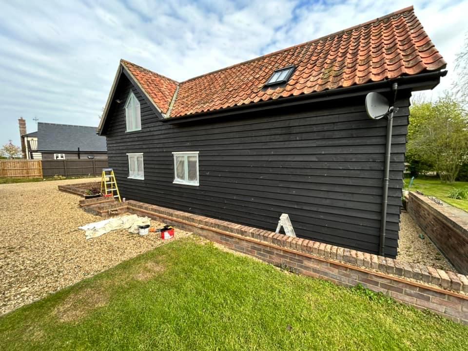 Black weatherboarded barn under a pantile roof