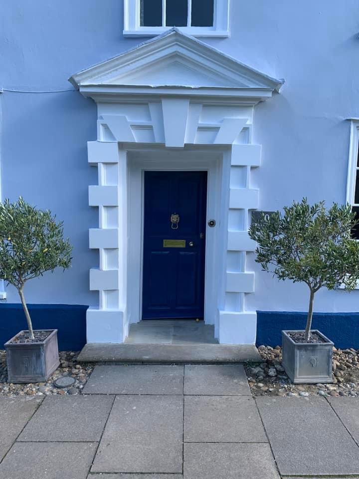 Close up of the restored doorcase with a navy front door