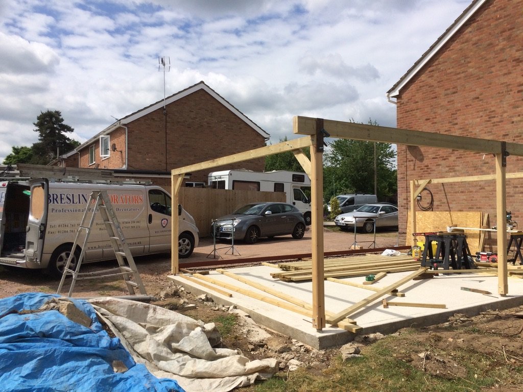 Garden room frame going up, with a Breslin van on the drive