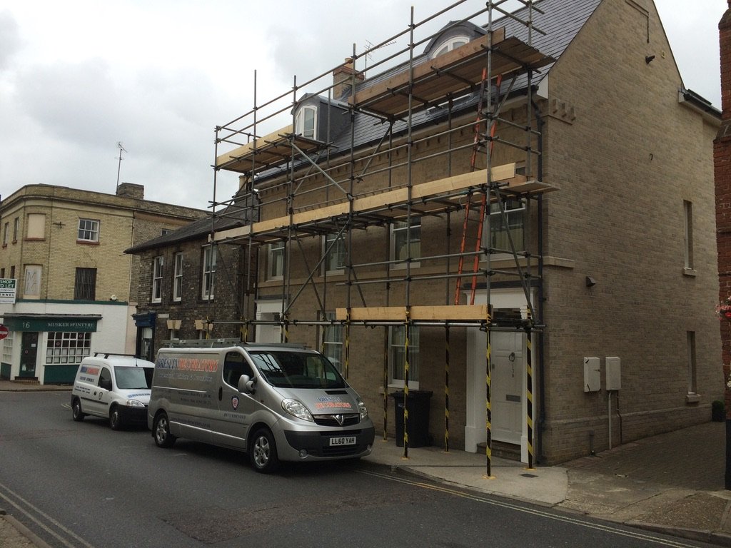 Scaffolded townhouse in town with the Breslin vans parked outside