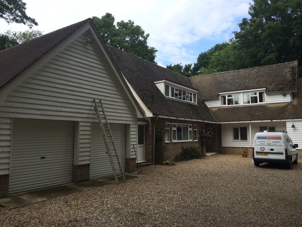 Weatherboarded double garage and house