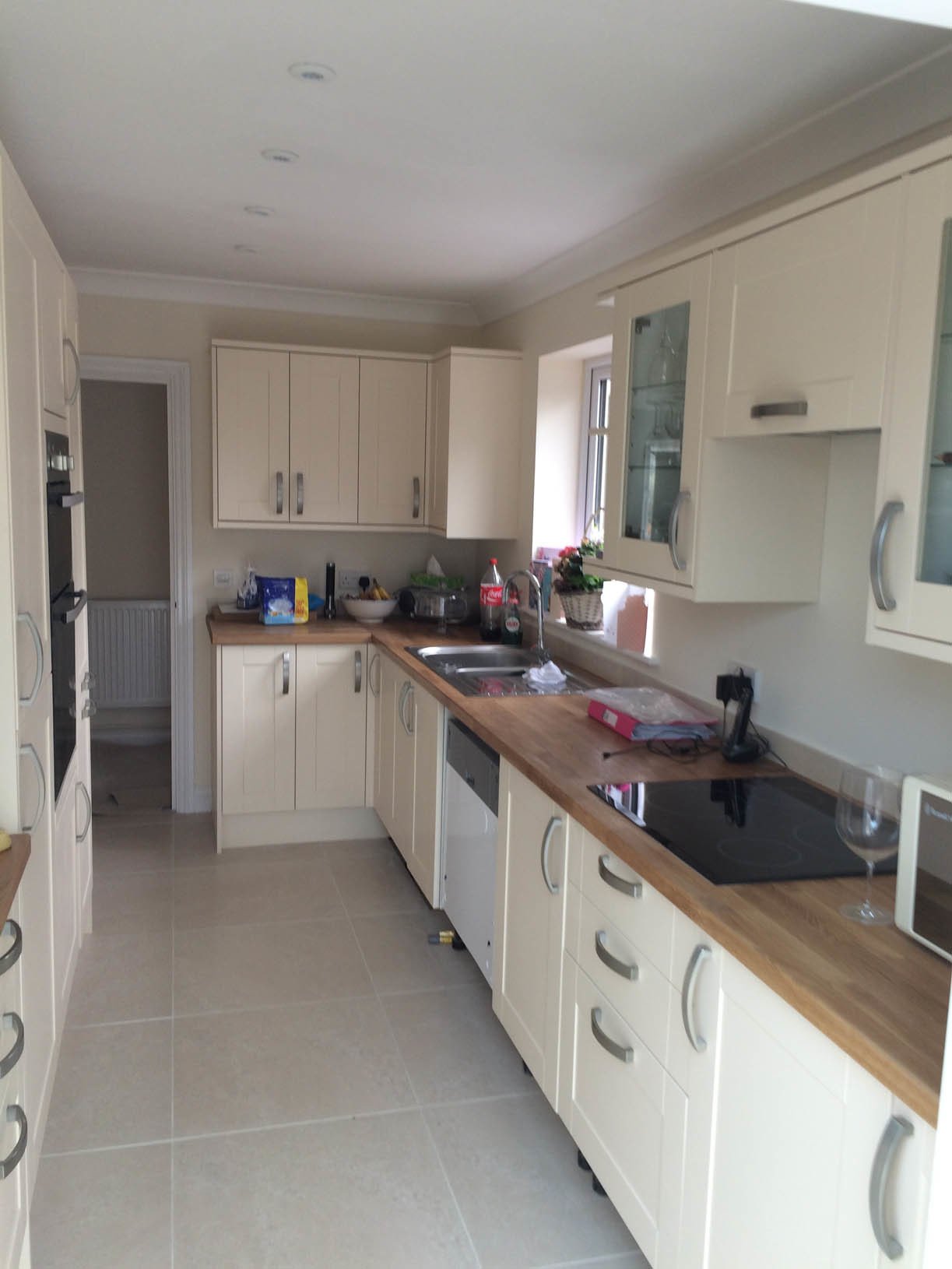 A finished kitchen with cream units and wooden worktops